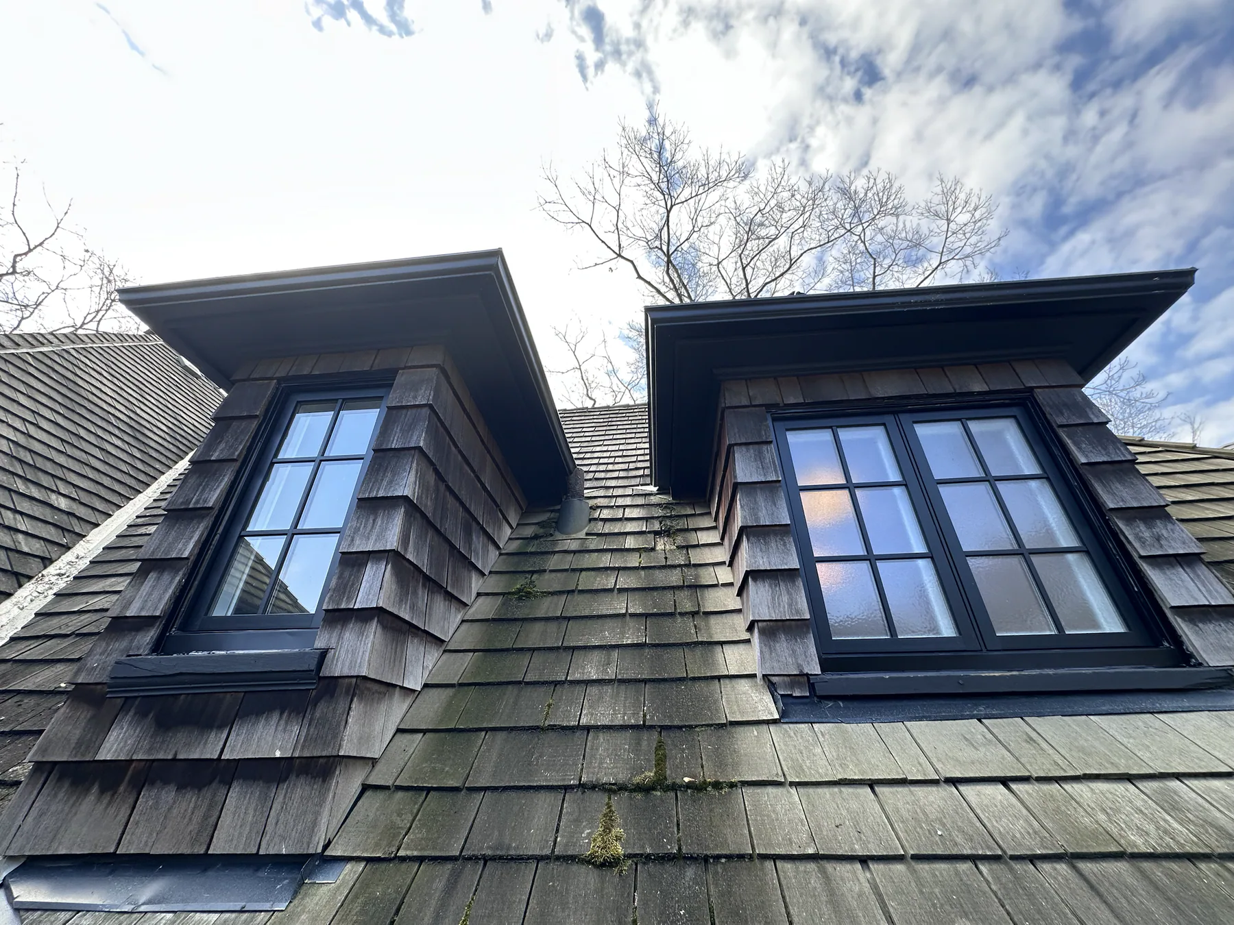 Dark heritage-style dormer windows with copper detailing